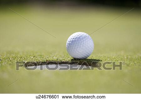 Close-up of a golf ball on the edge of a hole View Large Photo Image Stock Image - Close-up of a golf ball on the edge of a hole. Fotosearch