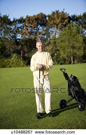 Stock Photo - Man standing on a golf course. Fotosearch