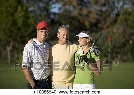 Stock Image - Portrait of three friends on a golf course. Fotosearch