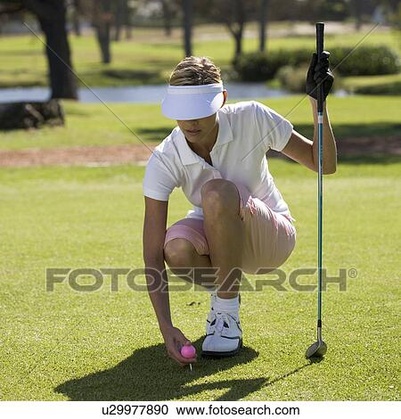 Woman playing golf, teeing up View Large Photo Image Stock Image - Woman playing golf, teeing up. Fotosearch