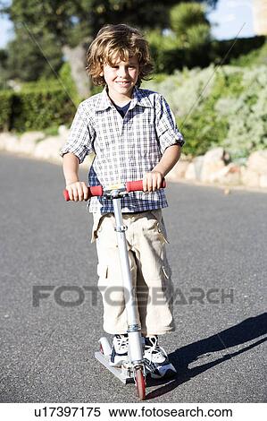 A young boy on a scooter View Large Photo Image Stock Photography - A young boy on a scooter. Fotosearch