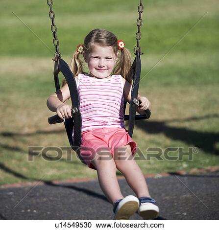 A young girl on a swing View Large Photo Image Stock Image - A young girl on a swing. Fotosearch