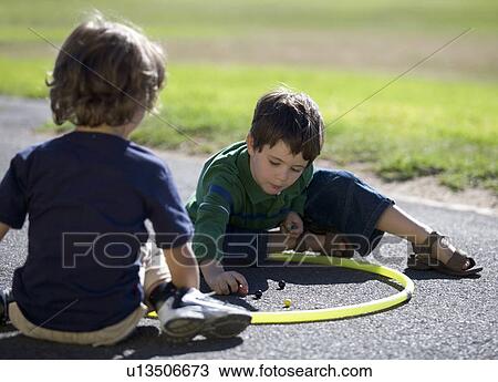 Two young boys playing marbles View Large Photo Image Stock Image - Two young boys playing marbles. Fotosearch