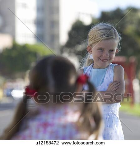 Stock Image - Two young girls at a school playground. Fotosearch