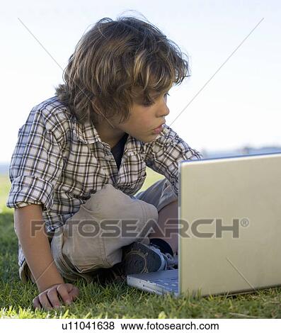 Young boy with a laptop computer View Large Photo Image Stock Photo - Young boy with a laptop computer. Fotosearch