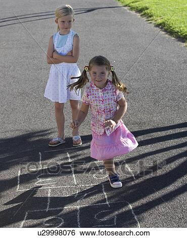 Young girls playing hopscotch View Large Photo Image Stock Photograph - Young girls playing hopscotch. Fotosearch