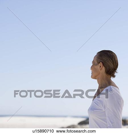 A mature woman standing on a beach View Large Photo Image Stock Image - A mature woman standing on a beach. Fotosearch
