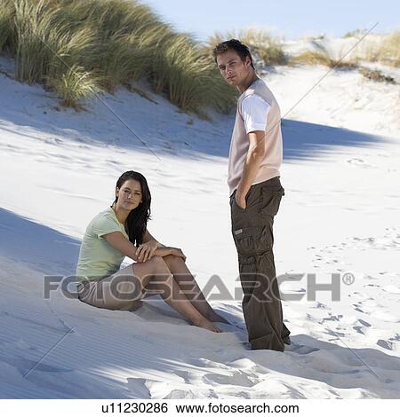 A young couple on a beach View Large Photo Image Stock Photograph - A young couple on a beach. Fotosearch