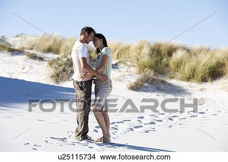 A young couple walking in sand dunes View Large Photo Image Picture - A young couple walking in sand dunes. Fotosearch