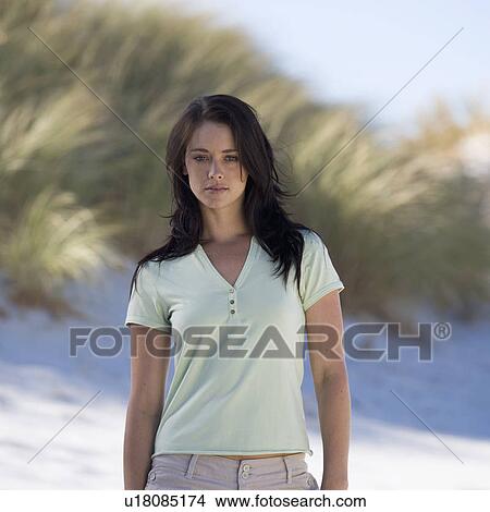 A young woman standing on a beach View Large Photo Image Picture - A young woman standing on a beach. Fotosearch