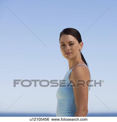 Stock Photograph - Portrait of a woman with the sea behind her. Fotosearch