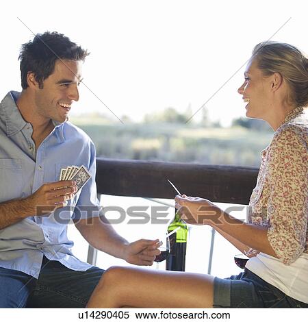 Stock Photography - A young couple playing cards. Fotosearch