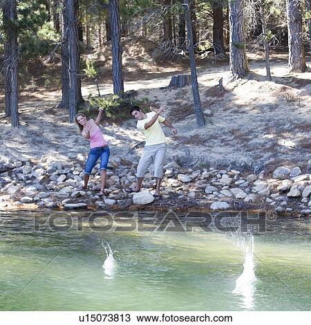 Stock Image - A young couple skimming stones . Fotosearch