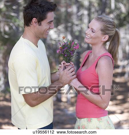 A young couple with a bouquet of flowers View Large Photo Image Stock Image - A young couple with a bouquet of flowers. Fotosearch