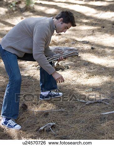 A young man collecting fire wood View Large Photo Image Stock Photograph - A young man collecting fire wood. Fotosearch