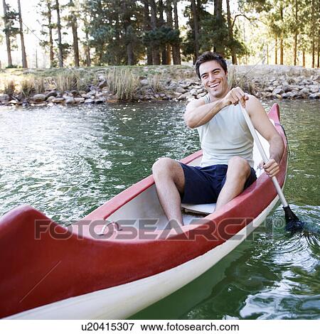 Stock Photo - A young man in a canoe. Fotosearch