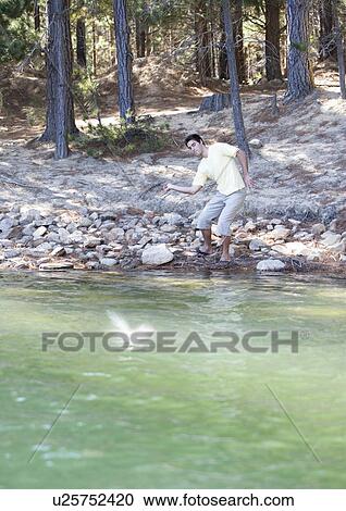 A young man skimming stones View Large Photo Image Stock Image - A young man skimming stones. Fotosearch