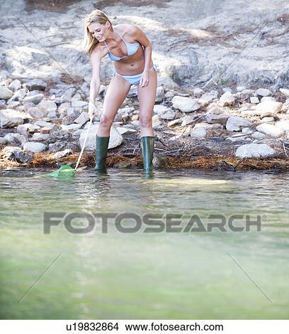 A young woman in a bikini with a fishing net View Large Photo Image Picture - A young woman in a bikini with a fishing net. Fotosearch
