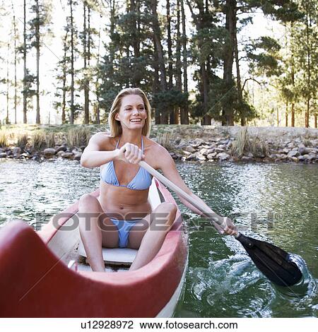 Stock Image - A young woman in a canoe. Fotosearch