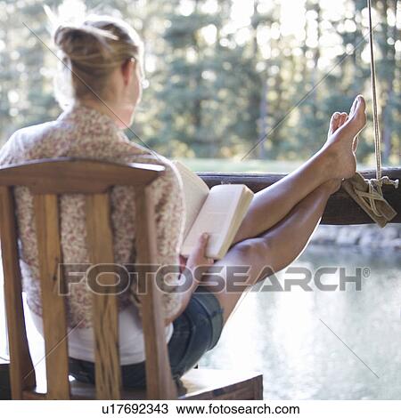 A young woman reading a book View Large Photo Image Stock Image - A young woman reading a book. Fotosearch