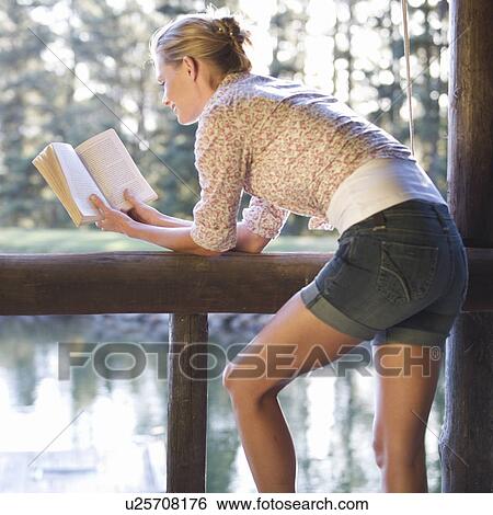Stock Photograph - A young woman reading a book. Fotosearch