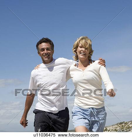 Stock Photography - A mature couple on a beach. Fotosearch
