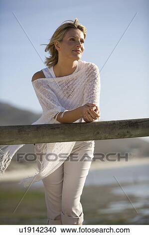 Stock Image - A woman standing on a beach. Fotosearch