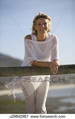 Stock Photo - A woman standing on a beach. Fotosearch