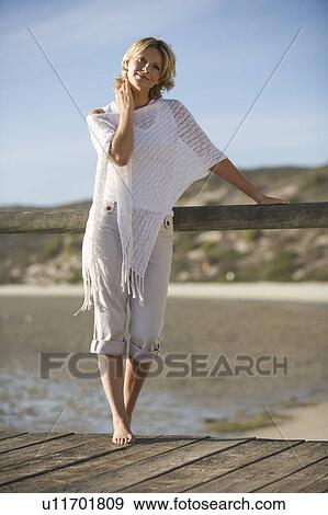 A woman standing on a boardwalk View Large Photo Image Stock Photo - A woman standing on a boardwalk. Fotosearch