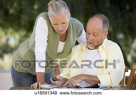 Stock Photo - A senior couple discussing an article in a paper. Fotosearch