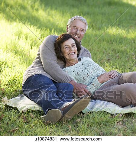 Stock Image - A senior couple laying on a rug. Fotosearch