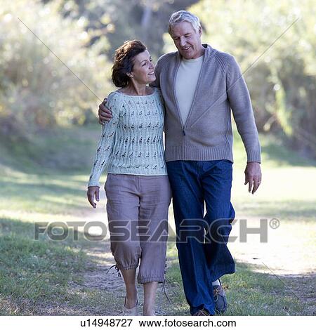 Stock Photo - A senior couple walking in the countryside. Fotosearch