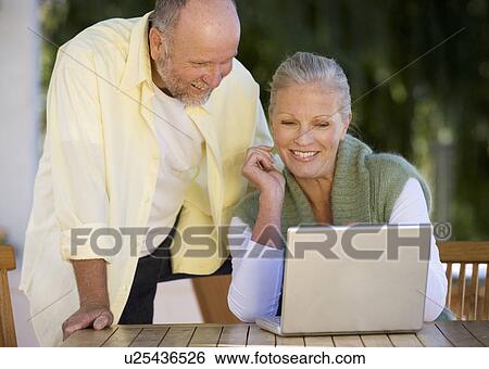 A senior couple working on a laptop View Large Photo Image Stock Photograph - A senior couple working on a laptop. Fotosearch