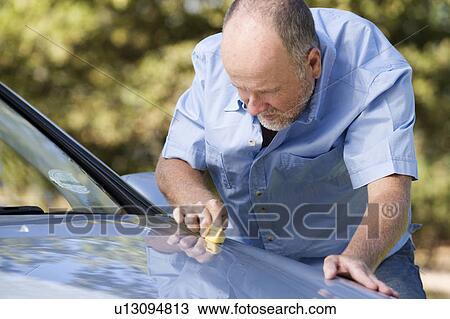 Stock Image - A senior man cleaning his car. Fotosearch