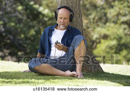 A senior man listening to music View Large Photo Image Stock Photo - A senior man listening to music. Fotosearch