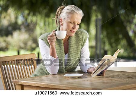 A senior woman reading a book View Large Photo Image Stock Image - A senior woman reading a book. Fotosearch