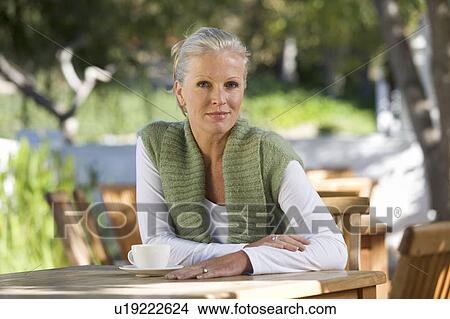 A senior woman sitting in a garden View Large Photo Image Picture - A senior woman sitting in a garden. Fotosearch