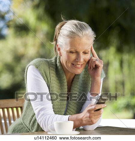 Stock Image - A senior woman talking on a mobile phone. Fotosearch