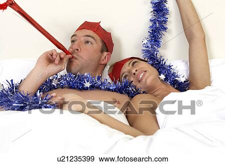 Stock Photo - Young couple in bed after a party. Fotosearch