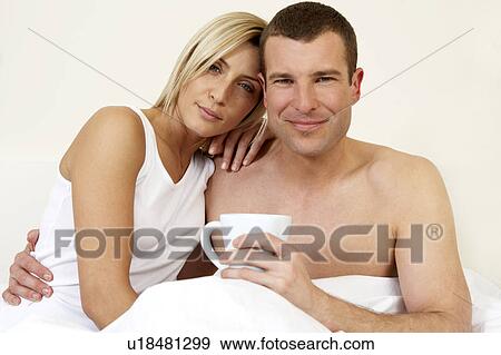 Young couple in bed having breakfast View Large Photo Image Stock Photo - Young couple in bed having breakfast. Fotosearch