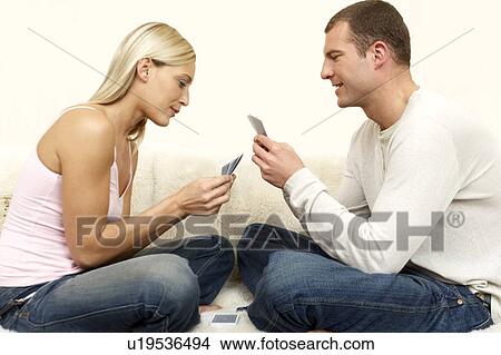 Young couple playing a game of cards on the sofa View Large Photo Image Picture - Young couple playing a game of cards on the sofa. Fotosearch
