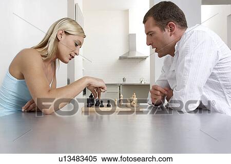 Young couple playing a game of chess in the kitchen View Large Photo Image Stock Photography - Young couple playing a game of chess in the kitchen. Fotosearch