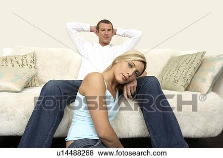 Young couple relaxing on the sofa View Large Photo Image Stock Photo - Young couple relaxing on the sofa. Fotosearch