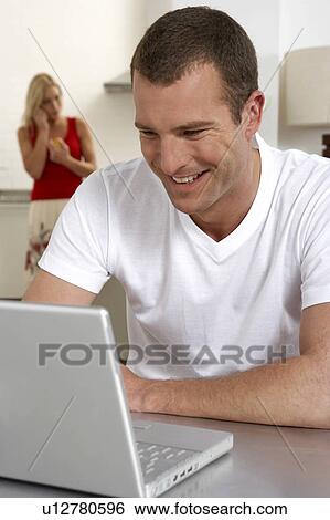 Stock Photograph - Young man working from home. Fotosearch