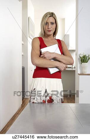 Young woman holding a laptop View Large Photo Image Stock Photograph - Young woman holding a laptop. Fotosearch