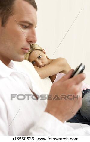 Stock Photograph - Young woman waiting for her partner to finish a mobile phone call. Fotosearch