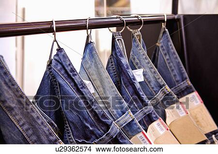 A stack of jeans hanging on the shelf in a row, Clothing Store View Large Photo Image Picture - A stack of jeans hanging on the shelf in a row, Clothing Store. Fotosearch