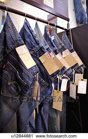 A stack of jeans hanging on the shelf in a row, Clothing Store View Large Photo Image Stock Image - A stack of jeans hanging on the shelf in a row, Clothing Store. Fotosearch