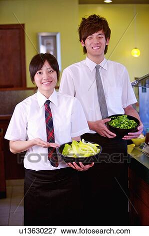 Waiter and waitress standing and serving a dish, Restaurant View Large Photo Image Stock Photo - Waiter and waitress standing and serving a dish, Restaurant. Fotosearch