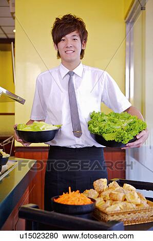 Young waiter preparing for the food in the restaurant, Restaurant View Large Photo Image Stock Image - Young waiter preparing for the food in the restaurant, Restaurant. Fotosearch